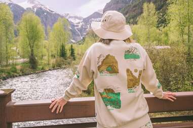 Woman wearing national parks sweatshirt overlooking river